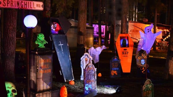A campsite at Sun Outdoors Lake Rudolph is lit up and set up to look like a graveyard with coffins, gravestones, and other Halloween decorations