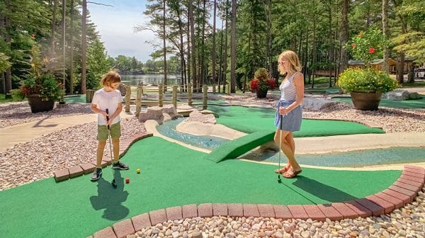 Mom watches son putt on the mini golf course at Sun Outdoors Lake Rudolph